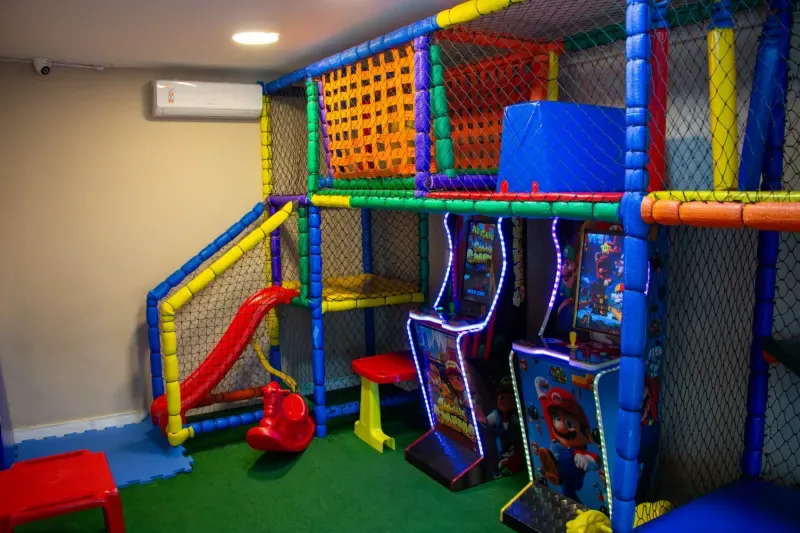Área Kids com brinquedos e arcade